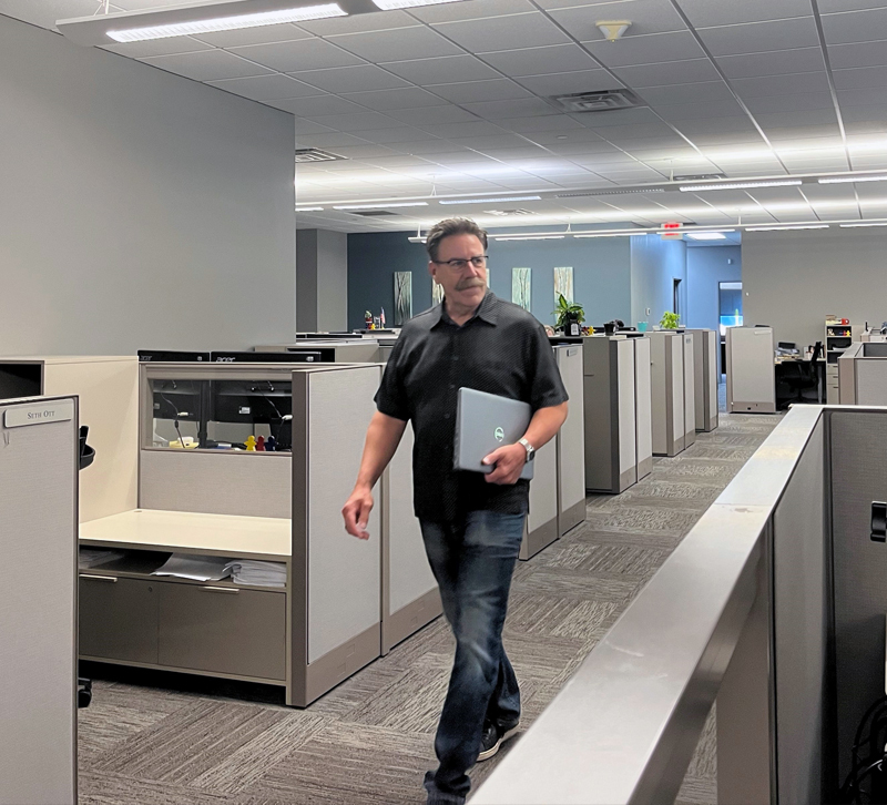 Employee walking down the hallway between cubicles