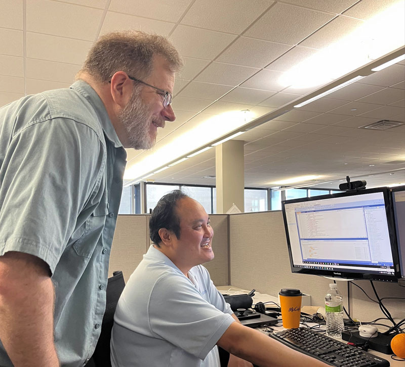Two teammates looking at their computer.