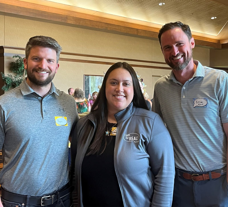 Employee standing by elevator with core values display.